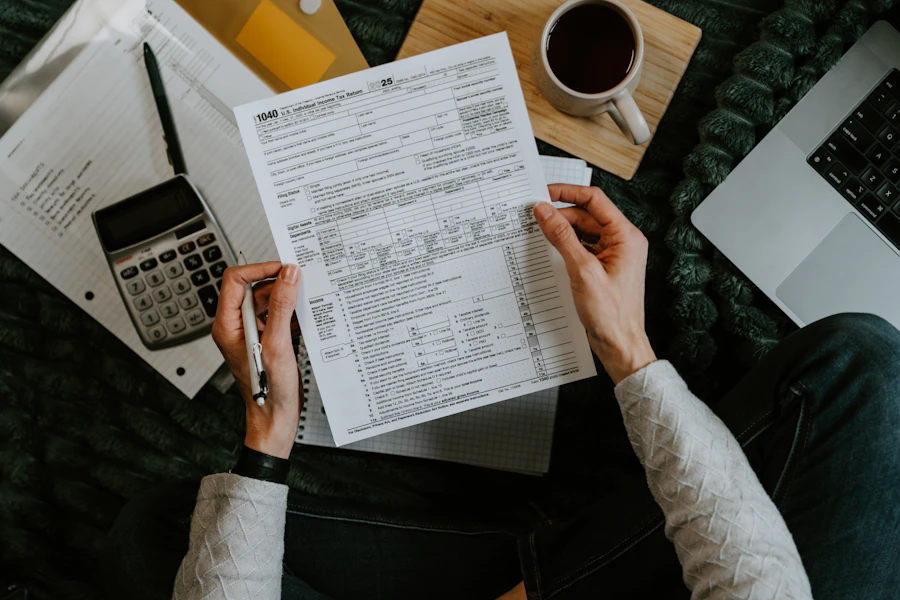 Hands holding tax forms beside a calculator