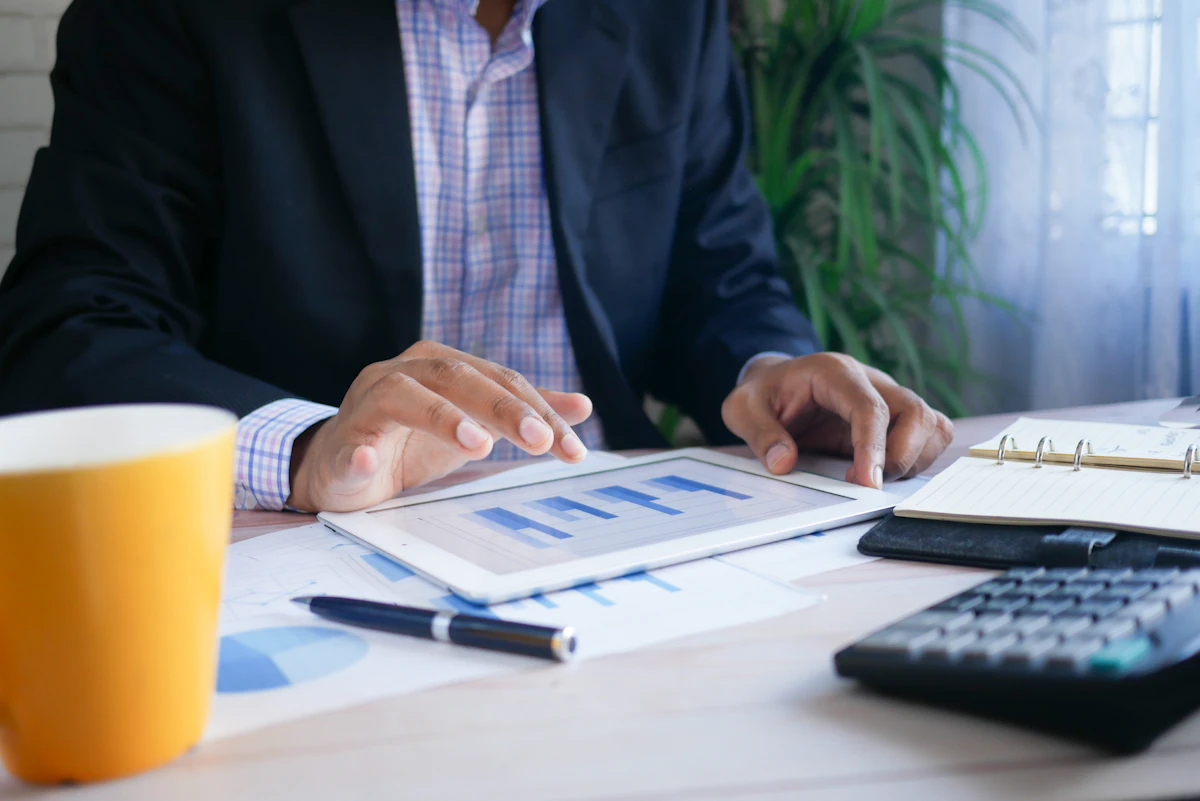 A professional reviewing financial figures with a tablet and calculator